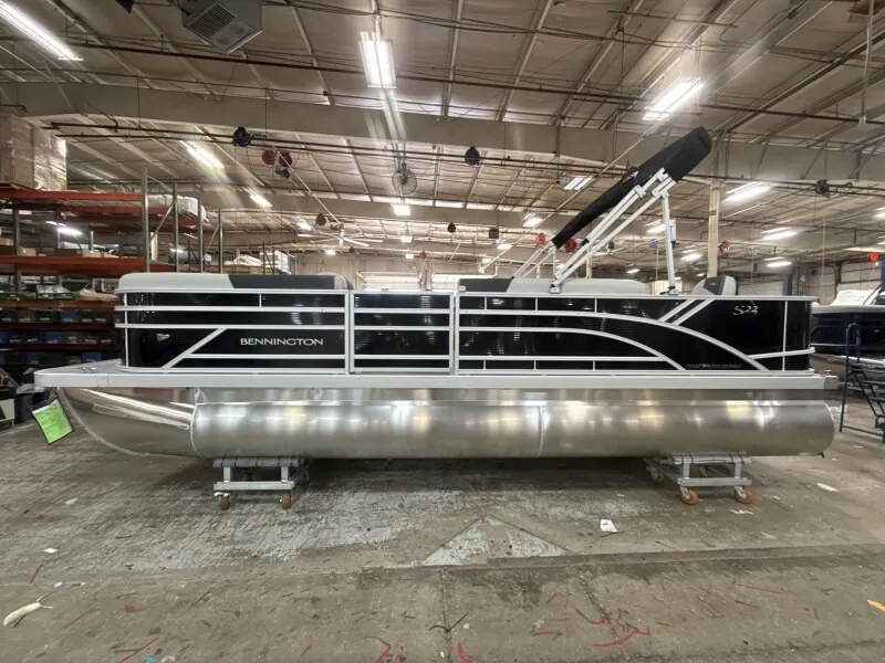 Slide: The Image of A Bennington 22 S1 Fish and Cruise pontoon boat is in a warehouse. It features a sleek design. - 4