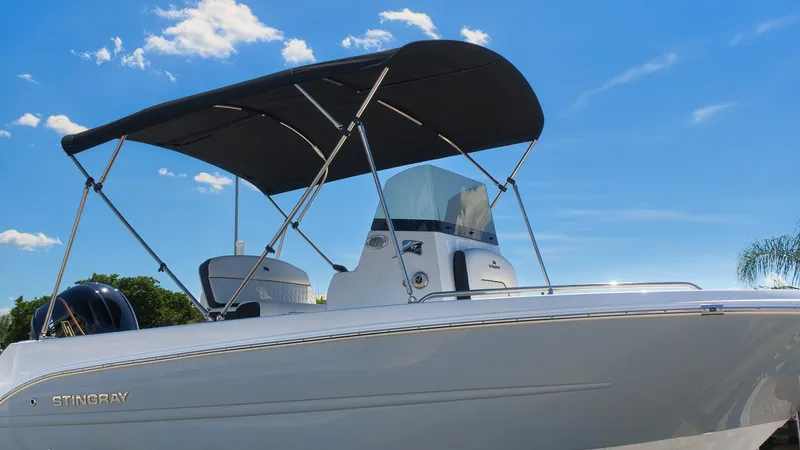 Slide: The Image of A modern 2027 Stingray 17 CC with a black sunshade and sleek white hull. - 2