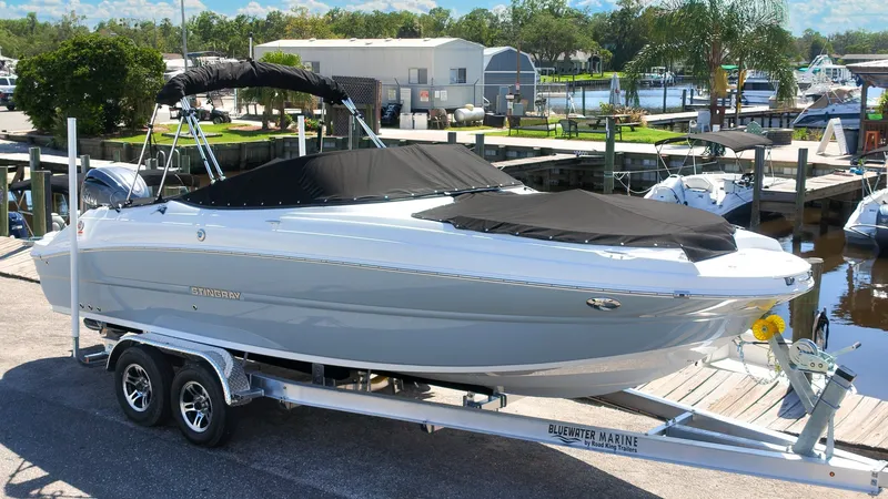 Slide: The Image of A modern 2027 Stingray 17 CC on a trailer, with a black cover, in a marina setting. - 3