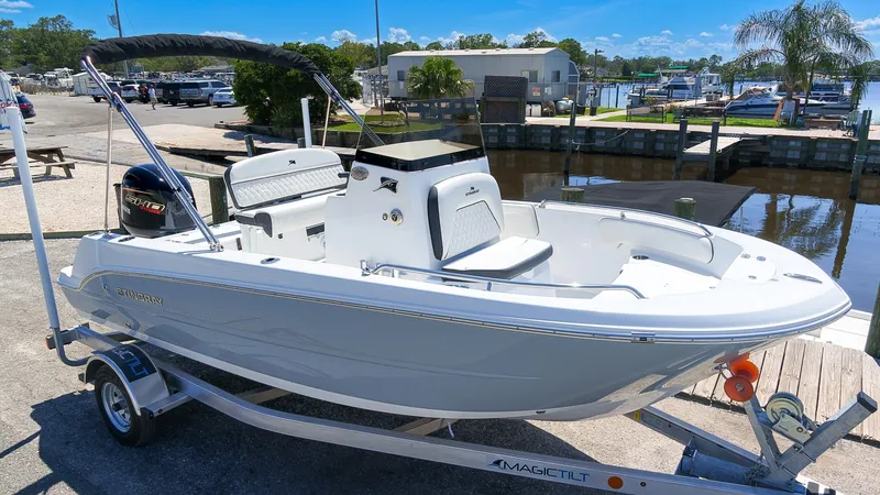 Slide: The Image of A white Stingray 17 CC boat from 2027 is on a trailer in a marina area. - 4