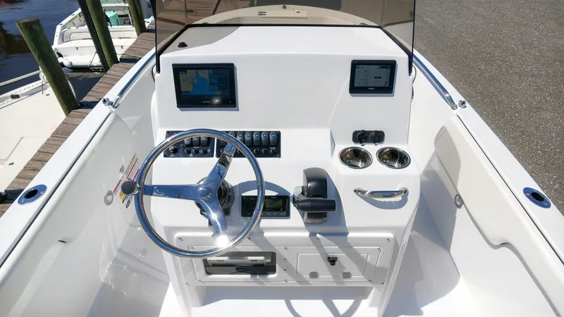 Slide: The Image of The image shows the cockpit of a Stingray 17 CC boat. It features a modern helm, instruments, and cup holders. - 10
