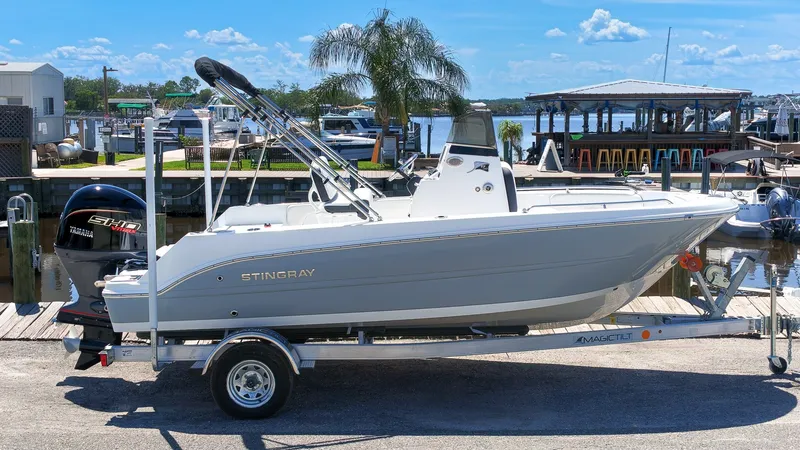 Slide: The Image of A modern 2027 Stingray 17 CC on a trailer, featuring an outboard motor, in a marina setting. - 20
