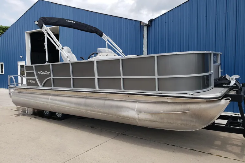 Slide: The Image of 2023 Bentley Pontoons 223 4 Party Fish pontoon boat parked outside blue building. - 2