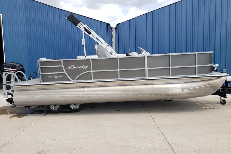 Slide: The Image of 2023 Bentley Pontoons 223 4 Party Fish boat with Mercury engine, parked by blue building. - 3