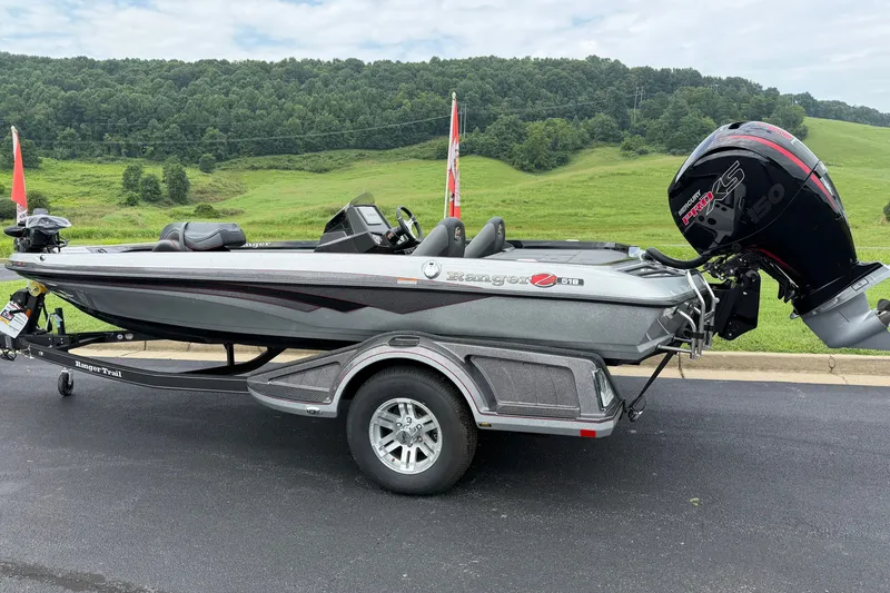 Slide: The Image of 2025 Ranger Z518 Cup-Equipped boat on trailer, parked with scenic green hills in background. - 5