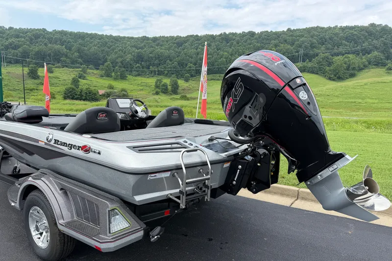 Slide: The Image of 2025 Ranger Z518 Cup-Equipped boat with powerful outboard motor, parked on a scenic road. - 2