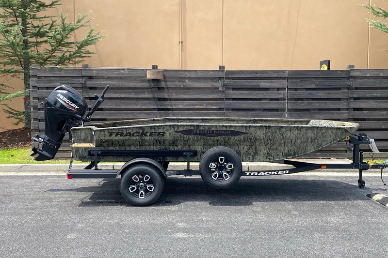 The Image of 2026 Tracker Grizzly 1650 T Prairie Wings Edition boat on trailer, parked outdoors. - 0