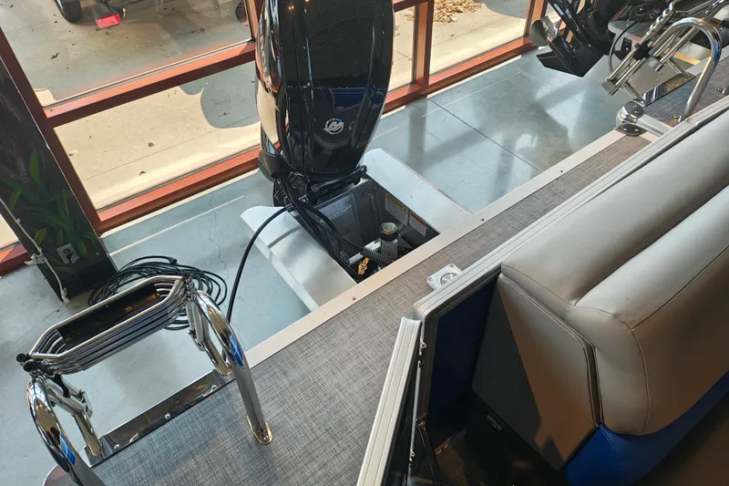 Slide: The Image of 2026 Sun Tracker Party Barge 20 DLX interior with motor and seating area. - 13