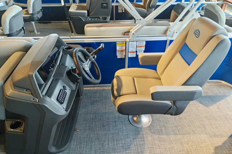 Slide: The Image of 2026 Sun Tracker Party Barge 20 DLX interior with captain's chair and steering console. - 11
