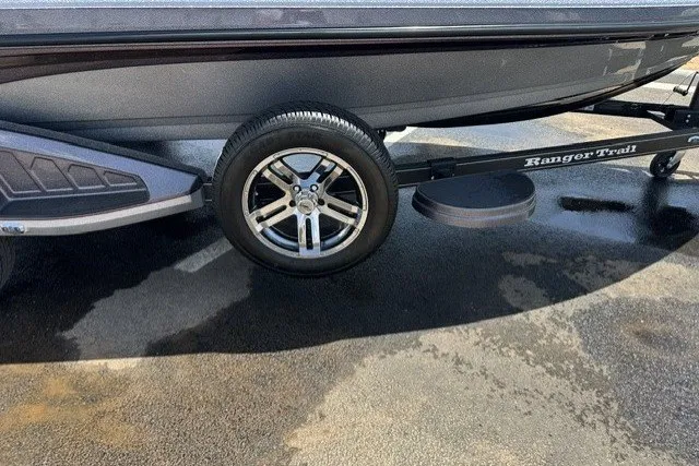 Slide: The Image of 2026 Ranger Z520 boat trailer with shiny alloy wheel on wet pavement. - 8