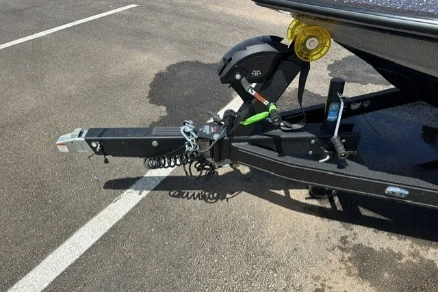 Slide: The Image of 2026 Ranger Z520 boat trailer hitch on asphalt, featuring safety chains and winch. - 11