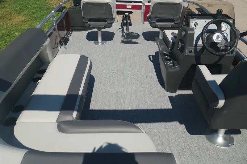 Slide: The Image of 2026 Sun Tracker Bass Buggy 18 DLX pontoon boat interior with seating and steering console. - 14