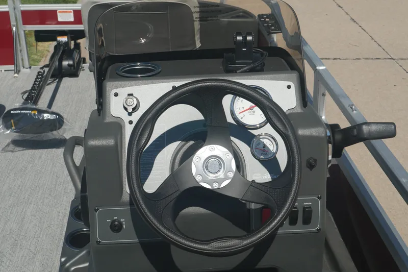 Slide: The Image of 2026 Sun Tracker Bass Buggy 18 DLX steering console with gauges and controls. - 12