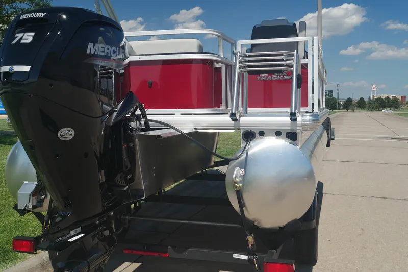 Slide: The Image of 2026 Sun Tracker Bass Buggy 18 DLX pontoon boat with Mercury 75 engine, parked outdoors. - 3