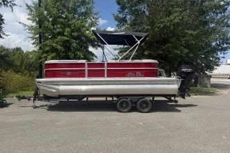 The Image of 2026 Sun Tracker Party Barge 20 DLX pontoon boat parked on a trailer. - 0