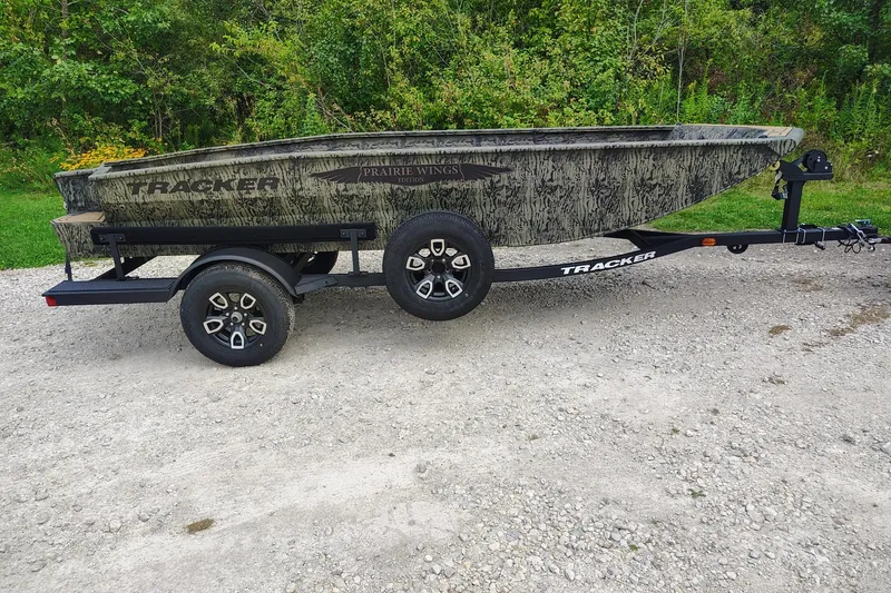 The Image of 2026 Tracker Grizzly 1650 T Prairie Wings Edition boat on trailer, parked on gravel. - 0