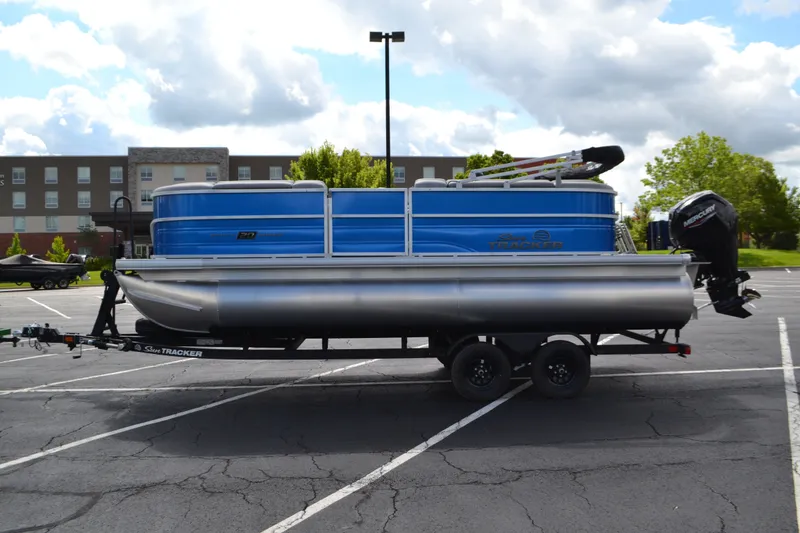 The Image of 2026 Sun Tracker Party Barge 20 DLX pontoon boat on trailer in parking lot. - 0