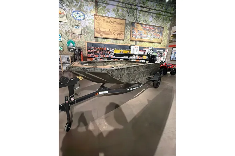 The Image of 2026 Tracker Grizzly 1650 T Prairie Wings Edition boat displayed in a showroom. - 0