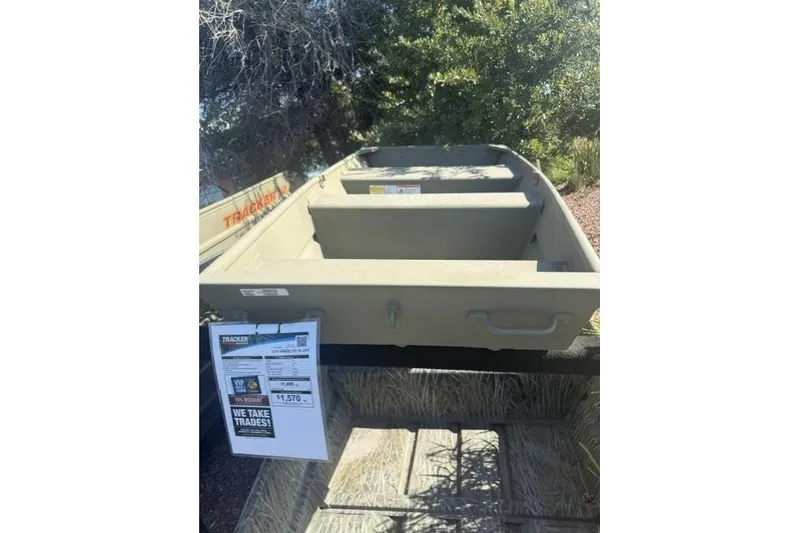 Slide: The Image of 2026 Tracker Grizzly 10 Jon boat displayed outdoors with trade-in offer sign. - 3