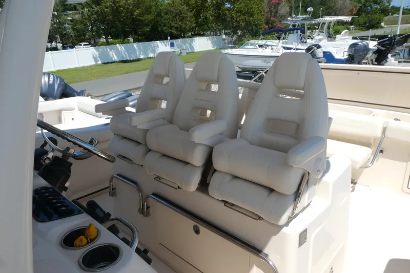 Slide: The Image of 2019 Grady-White Canyon 336 boat interior with plush white seating and steering console. - 6
