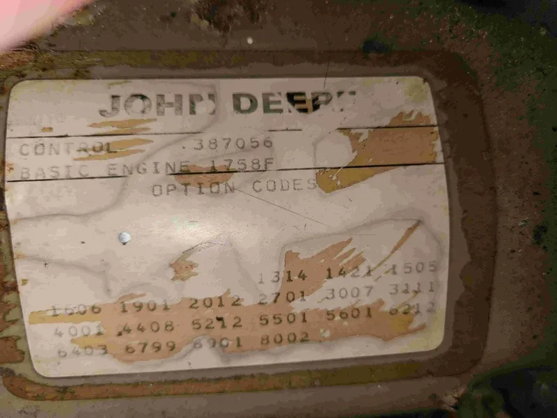 Slide: The Image of A worn John Deere nameplate with serial number and engine details. - 23