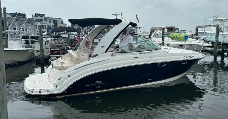 The Image of 2006 Chaparral Signature 276 boat docked in a marina, featuring sleek design and black hull. - 0