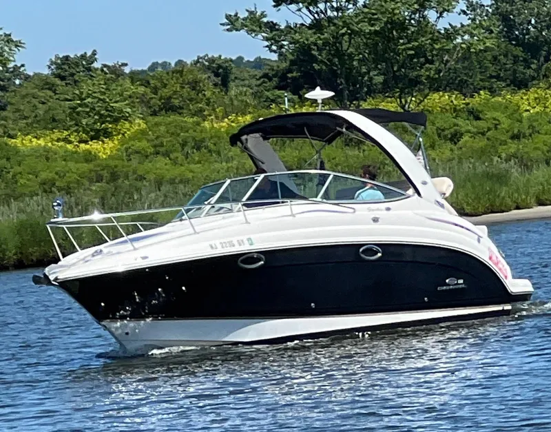 Slide: The Image of 2006 Chaparral Signature 276 boat cruising on a sunny day near lush greenery. - 3
