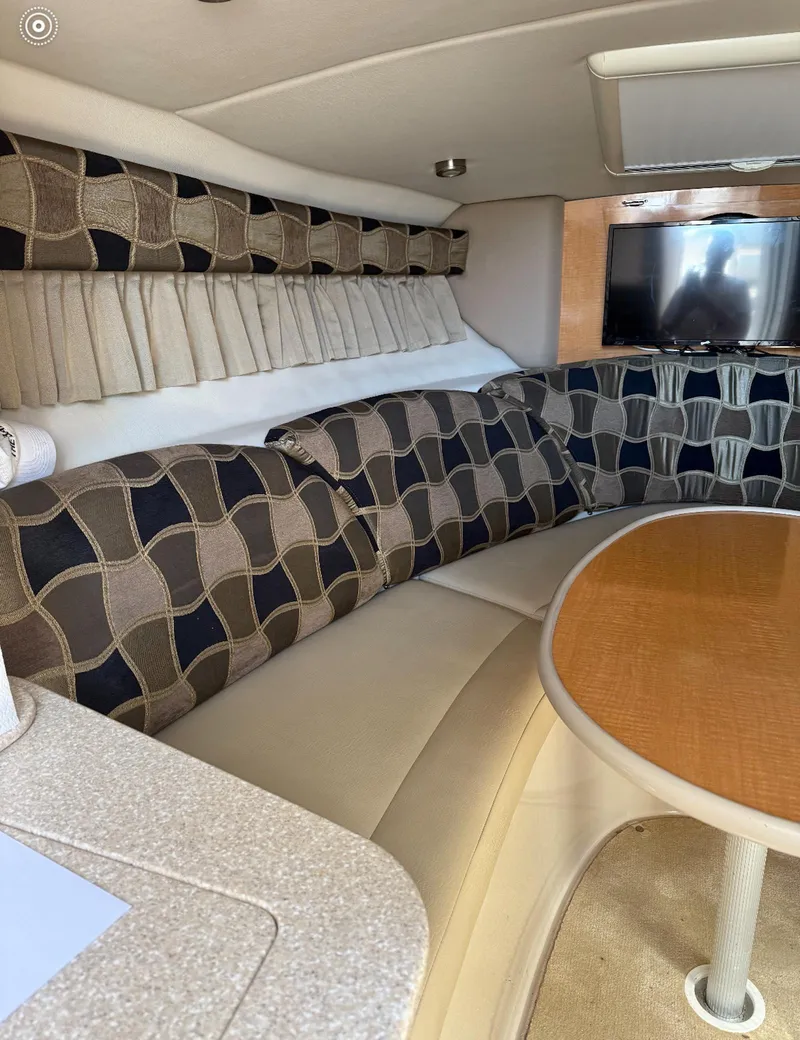 Slide: The Image of Interior of 2006 Chaparral Signature 276 with patterned seating and wooden table. - 6