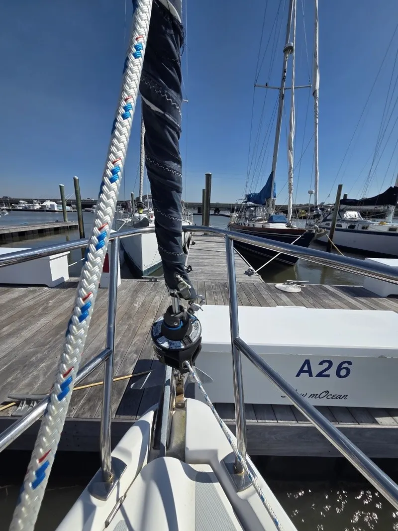 Slide: The Image of A sailboat is docked, featuring a blue sail and surrounded by other boats. - 17