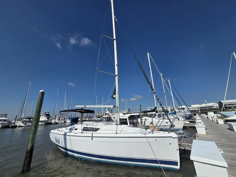 Slide: The Image of A white 2005 Hunter 31 sailboat is docked in a marina under a clear blue sky. - 20