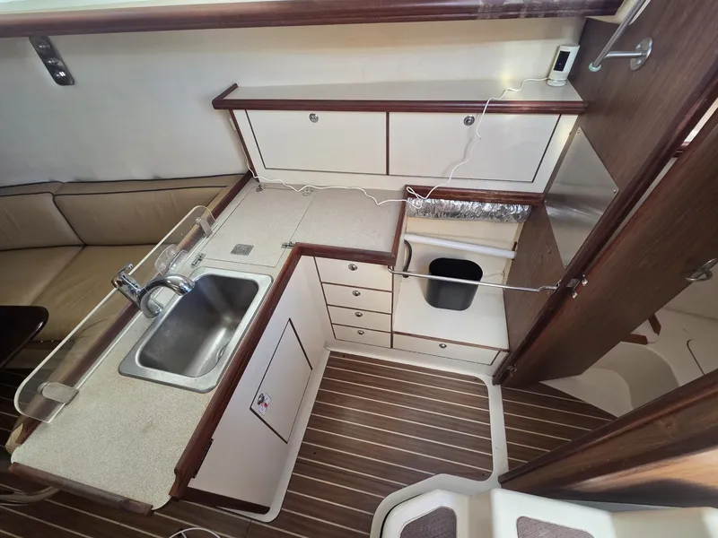 Slide: The Image of The galley of a 2005 Hunter 31 with a sink, countertop, and cabinets. - 6