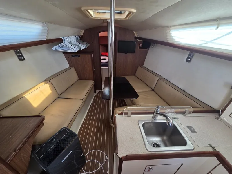 Slide: The Image of Interior of a 2005 Hunter 31 with cozy seating areas and a small kitchenette. - 3
