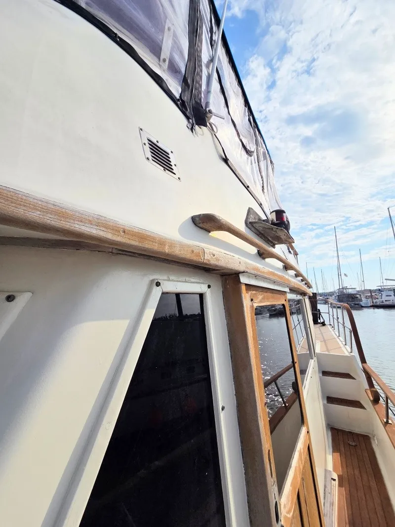Slide: The Image of A 1982 Sea Ranger 39 Sundeck with wooden details and a covered deck, docked in a marina. - 21