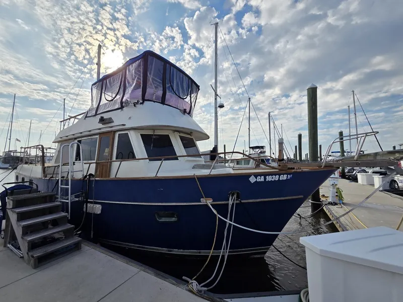 Slide: The Image of A 1982 Sea Ranger 39 Sundeck is docked at a marina on a sunny day. - 1