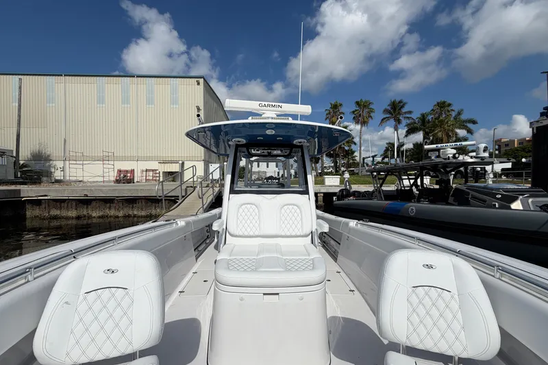 Slide: The Image of 2025 Sportsman Open 322 Center Console boat docked, featuring sleek white seating and modern design. - 8
