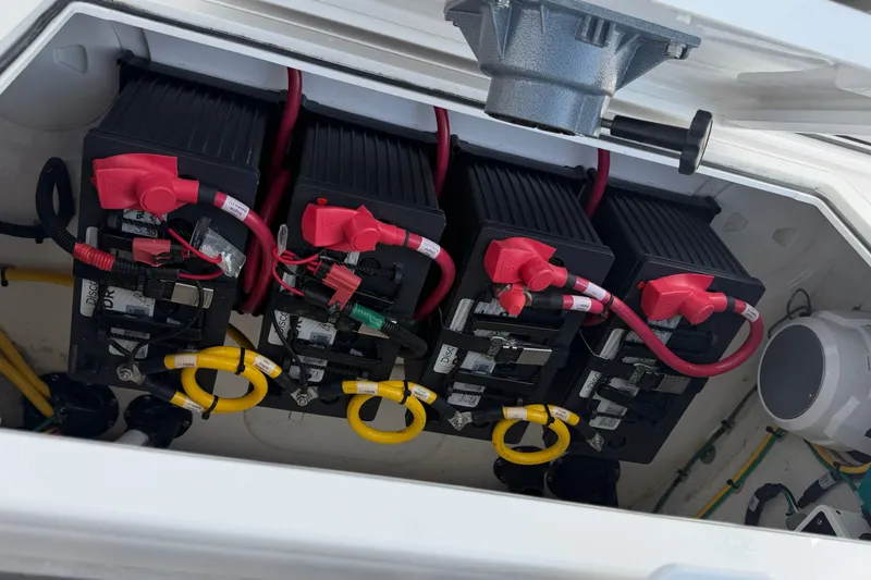 Slide: The Image of Battery compartment of 2025 Sportsman Open 322 Center Console boat, featuring four batteries. - 14