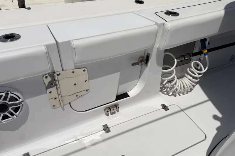 Slide: The Image of 2025 Sportsman Open 322 Center Console boat interior detail with speaker and coiled hose. - 13