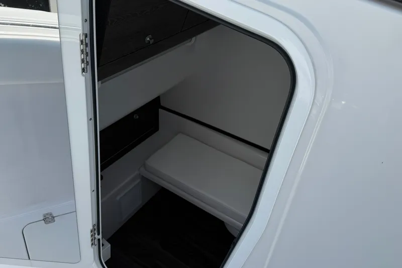 Slide: The Image of 2025 Sportsman Open 322 Center Console cabin interior with seating and storage. - 9