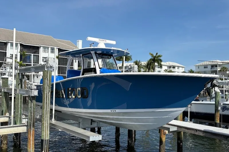The Image of 2025 Sportsman Open 322 Center Console boat docked at marina, blue hull, sunny day. - 0