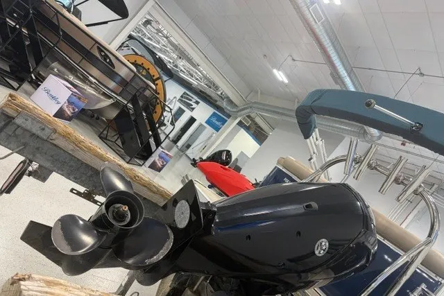 Slide: The Image of 2022 Avalon LSZ 2285 CR pontoon boat in showroom, featuring a powerful outboard motor. - 7
