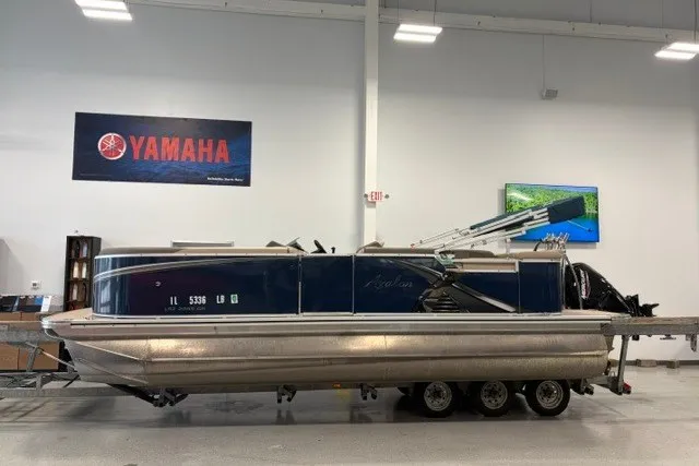 Slide: The Image of 2022 Avalon LSZ 2285 CR pontoon boat on trailer in showroom with Yamaha signage. - 1