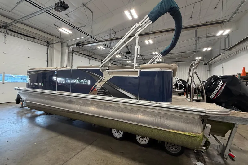 The Image of 2022 Avalon LSZ 2285 CR pontoon boat in a spacious indoor showroom. - 1