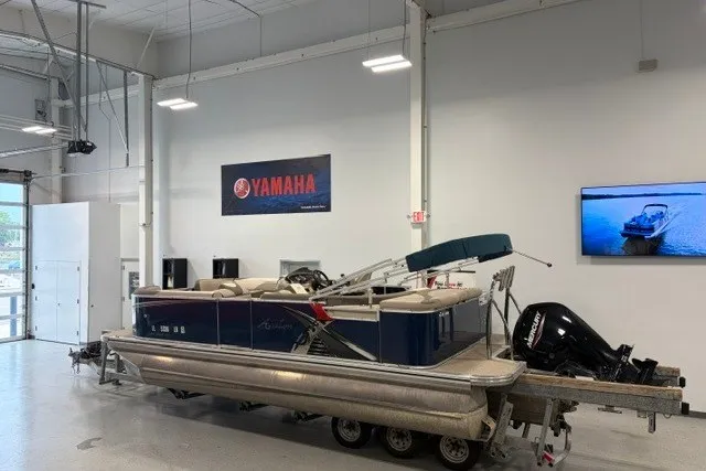 Slide: The Image of 2022 Avalon LSZ 2285 CR pontoon boat in showroom with Yamaha signage. - 2
