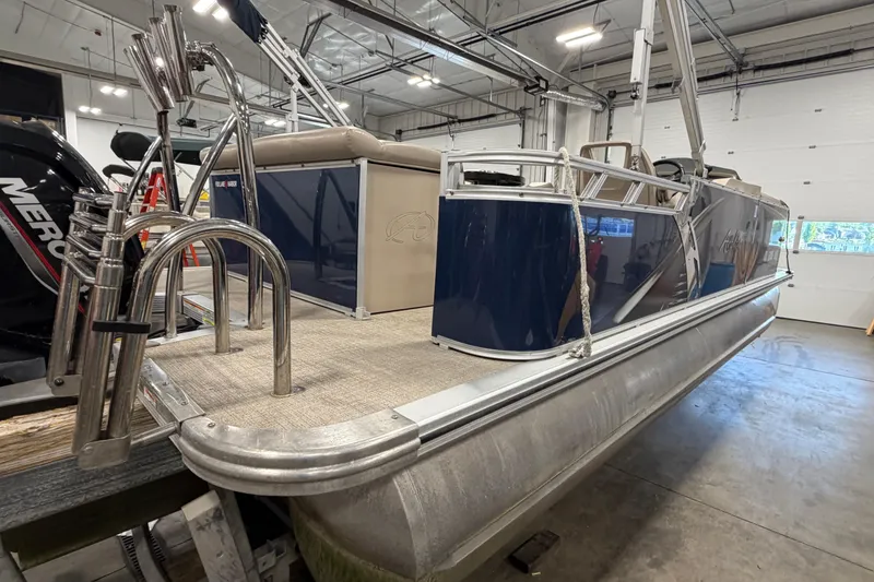 Slide: The Image of 2022 Avalon LSZ 2285 CR pontoon boat in a showroom, featuring sleek design and modern amenities. - 6