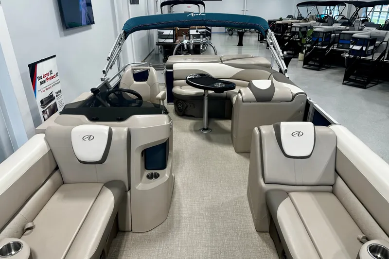 Slide: The Image of 2022 Avalon LSZ 2285 CR pontoon boat interior with beige seating and steering console. - 14