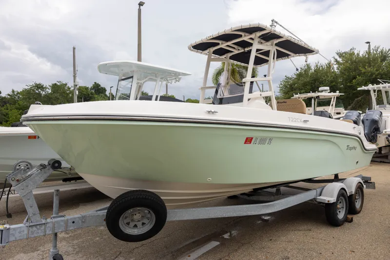 The Image of A 2022 Bayliner T22CX boat on a trailer, featuring a white and green hull. - 1
