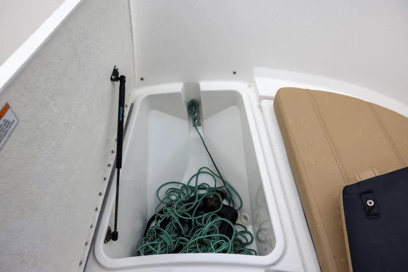 Slide: The Image of A storage compartment on a Bayliner T22CX boat with ropes and a buoy. - 13