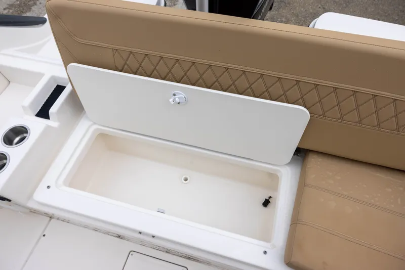 Slide: The Image of The image shows a beige seat with a white storage compartment lid on a Bayliner T22CX boat. - 17