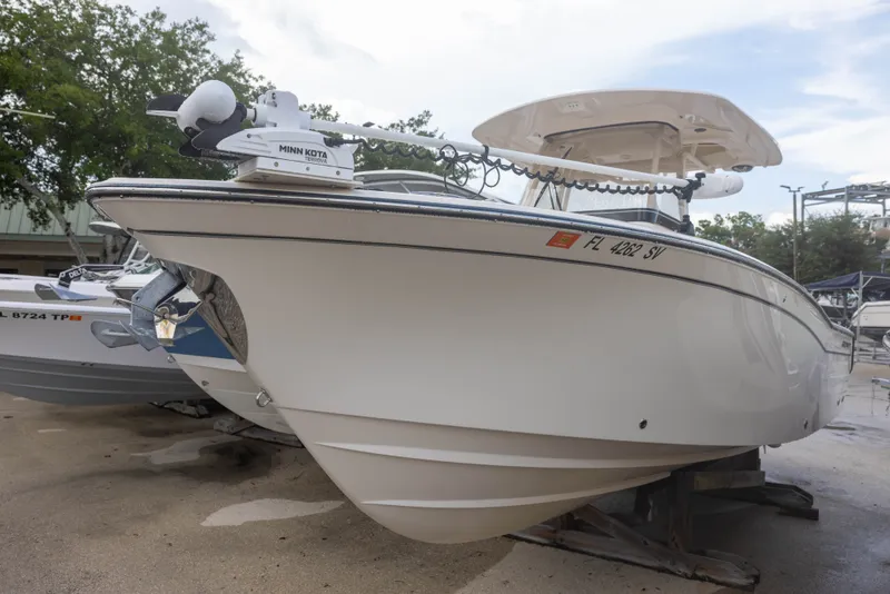 Slide: The Image of Grady-White Canyon 271, 2021 model, on a dry dock. The boat features a sleek, white design. - 2