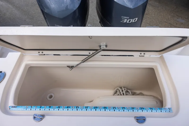 Slide: The Image of An open storage compartment on a Grady-White Canyon 271 boat with a measuring tape and rope. - 10